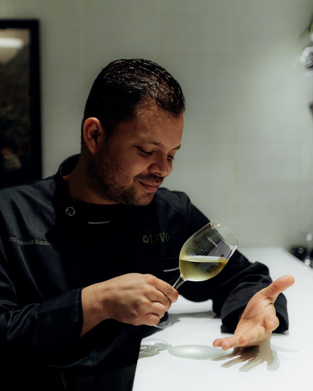 Retrato de Nelvin, Sommelier Nómada, catando una copa de vino